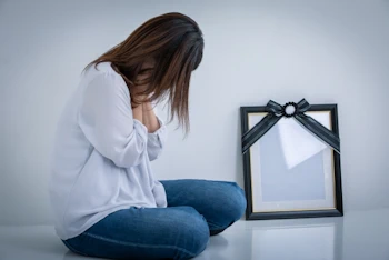 遺影を前に悲しむ女性